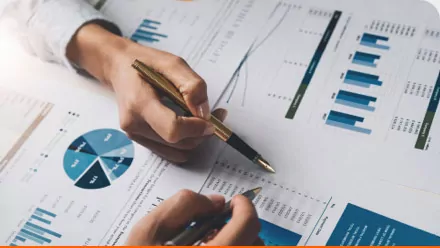 two people pointing at charts with pens